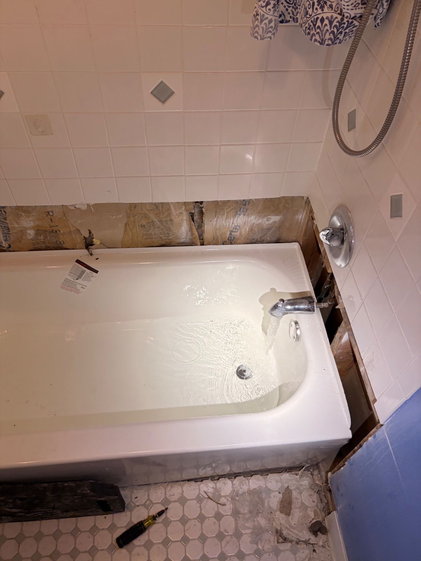 Bathtub and shower valve fixtures visible during bathroom plumbing work