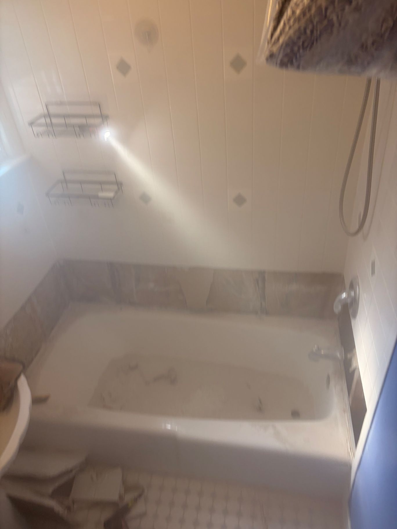 White bathtub and shower surround with trim and showerhead installed